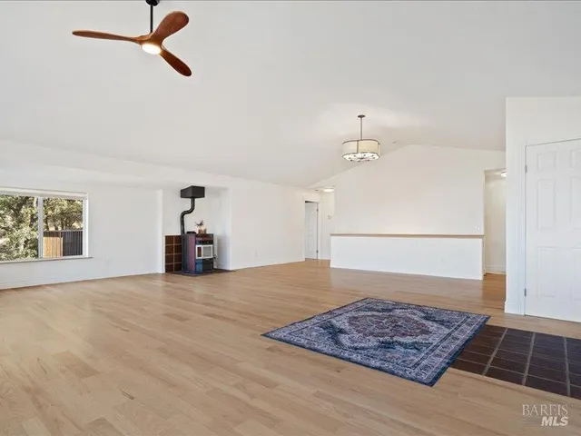 a view of a livingroom with wooden floor and a ceiling fan
