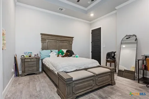 a bedroom with a bed table closet and a window