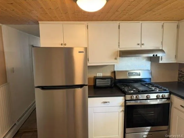 a kitchen with a refrigerator stove and white cabinets