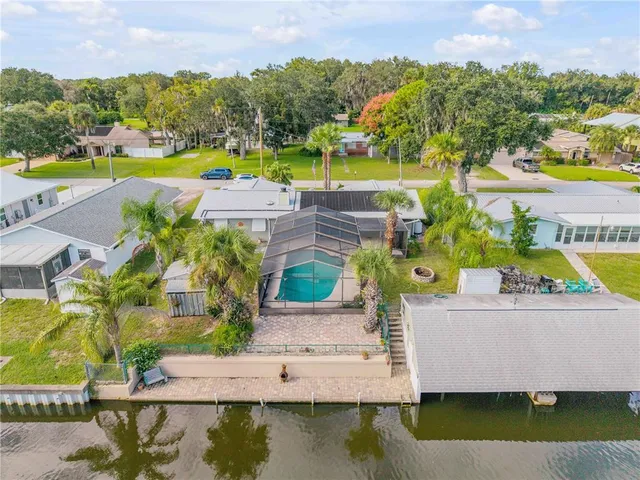 an aerial view of a house with a swimming pool and outdoor seating