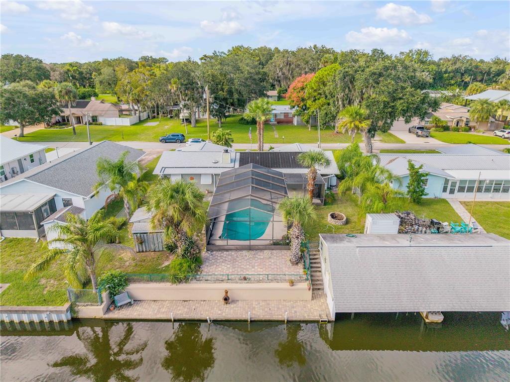 an aerial view of a house with a swimming pool and outdoor seating