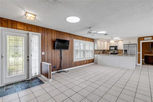 a large kitchen with kitchen island granite countertop a sink cabinets and stainless steel appliances