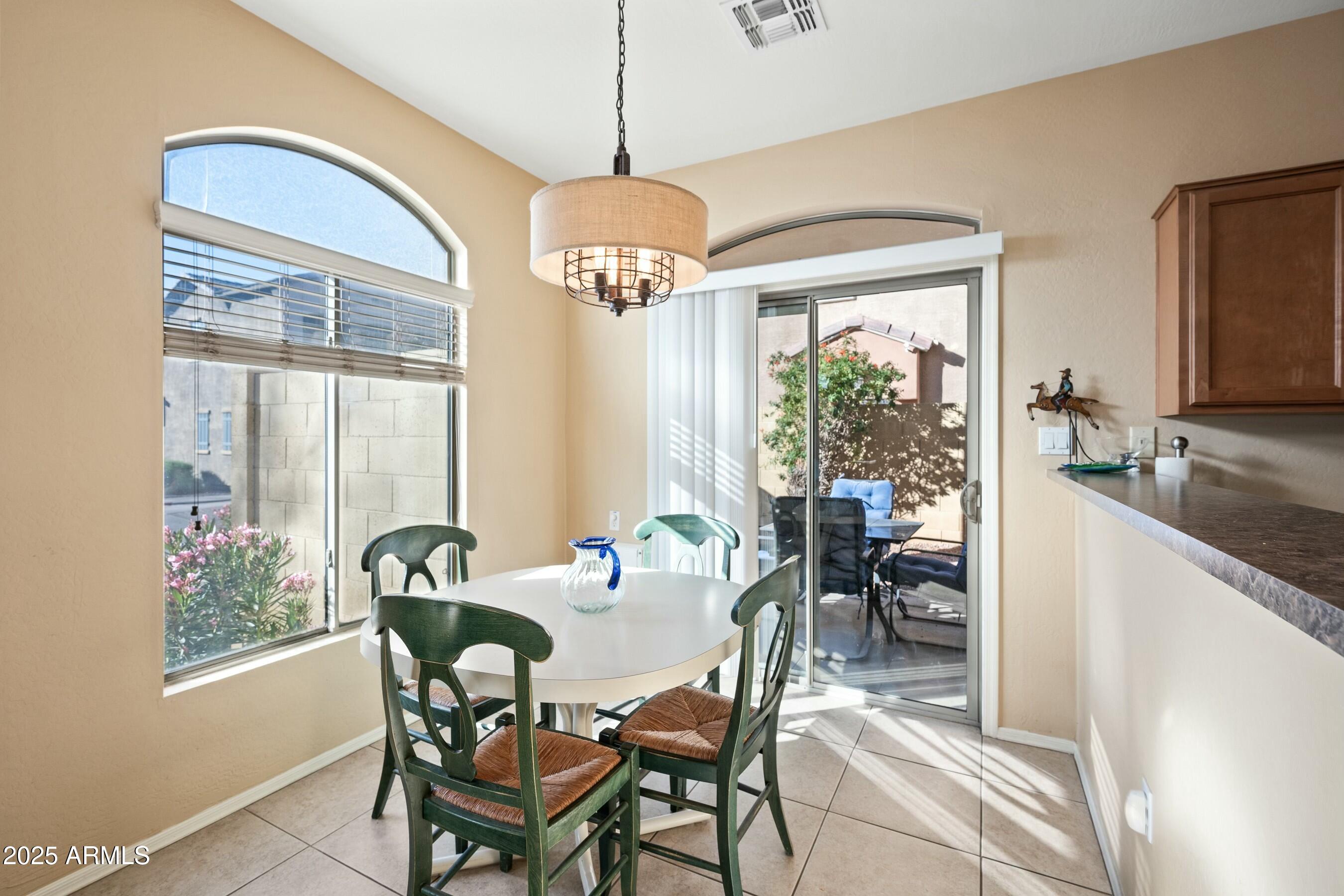 2150 East Bell Road, Unit 1130 Phoenix, AZ 85022 - Photo 11 of 39 a dining room with furniture a chandelier and window