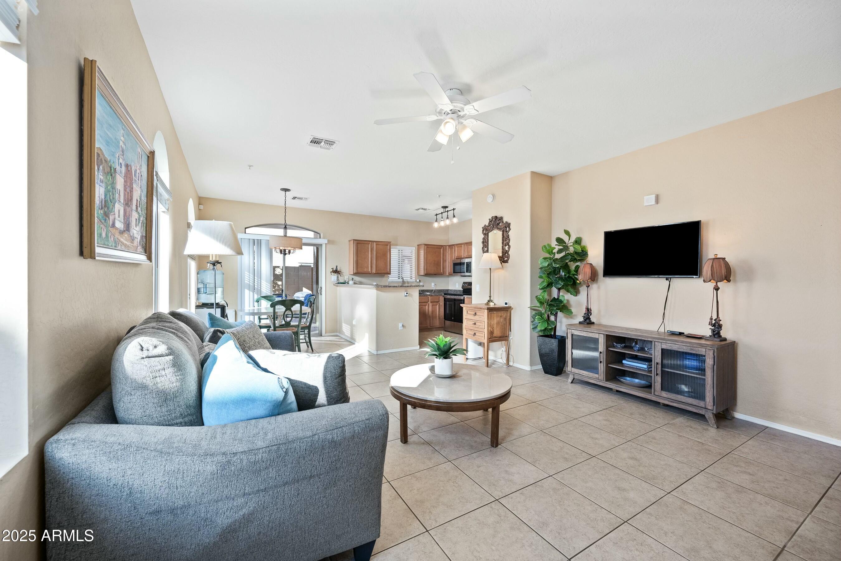 2150 East Bell Road, Unit 1130 Phoenix, AZ 85022 - Photo 3 of 39 a living room with furniture and a flat screen tv