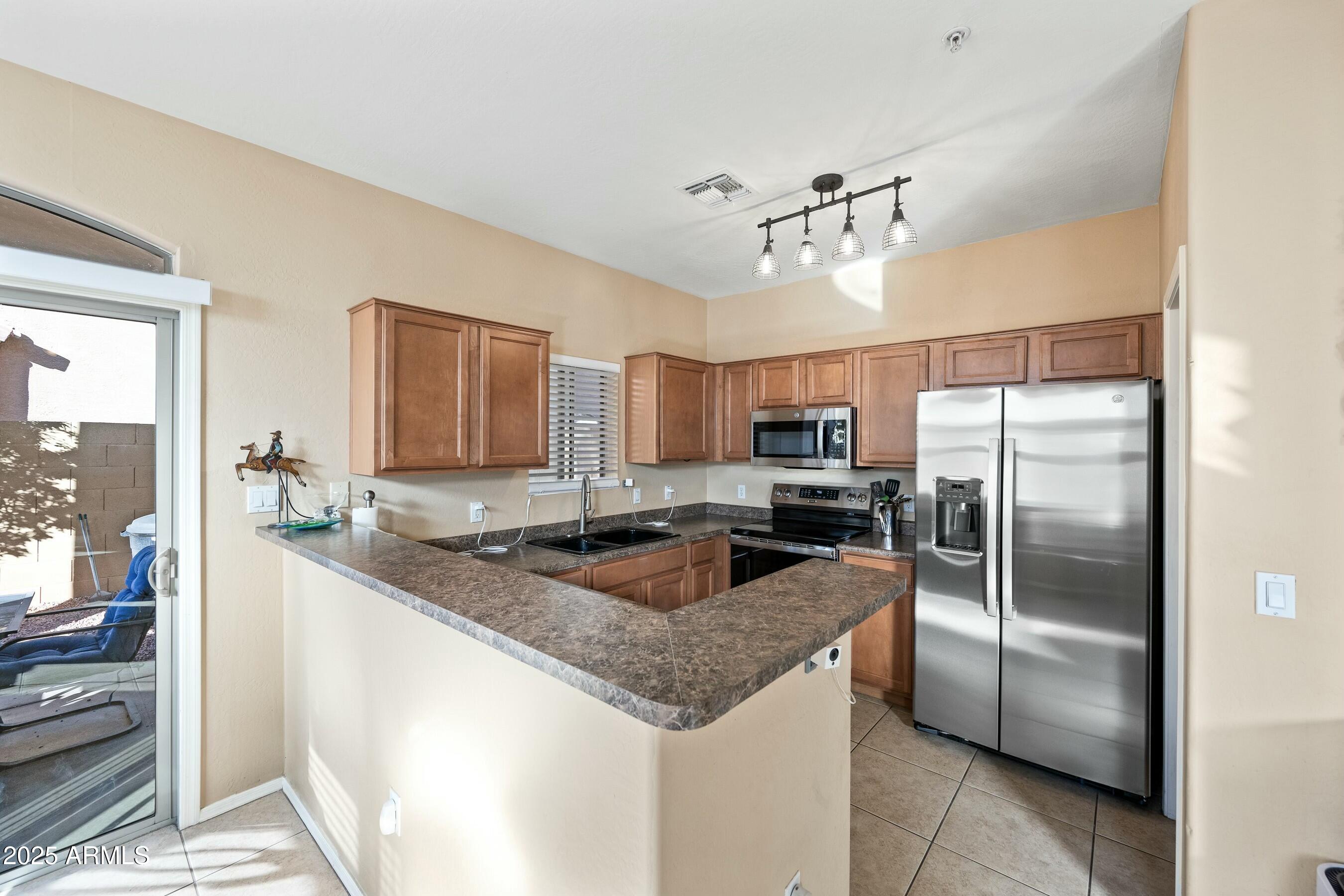 2150 East Bell Road, Unit 1130 Phoenix, AZ 85022 - Photo 6 of 39 a kitchen with granite countertop a refrigerator and a sink