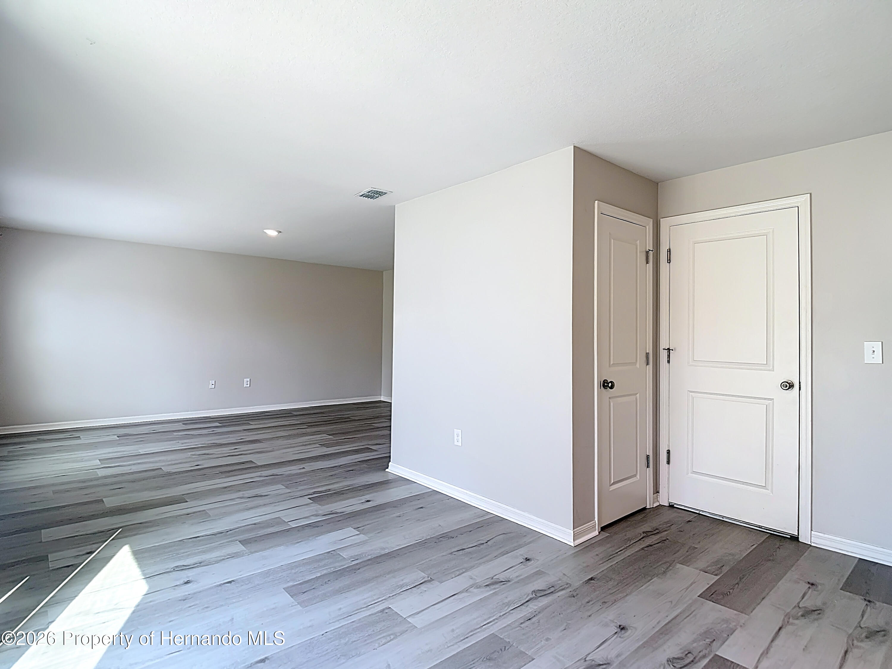 11374 Marcella Avenue Weeki Wachee, FL 34614 - Photo 27 of 70 a view of an empty room and wooden floor