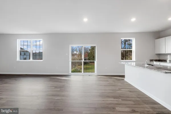 a view of a kitchen with wooden floor and a window
