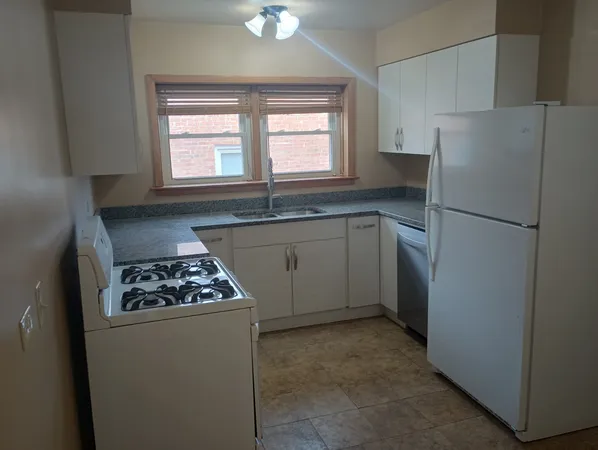 a kitchen with a stove a refrigerator and a sink