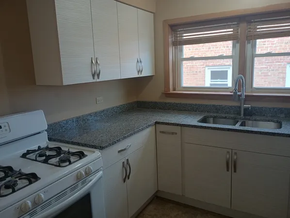 a kitchen with granite countertop white cabinets and white appliances