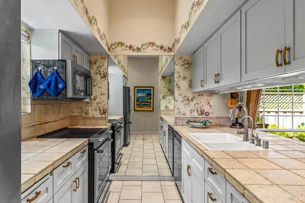 a kitchen with stainless steel appliances granite countertop a sink stove and refrigerator
