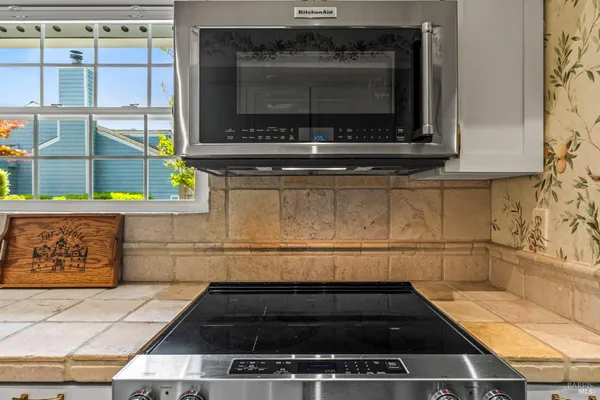 a kitchen with granite countertop a stove a microwave and a shower