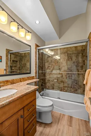 a bathroom with a granite countertop sink toilet and shower
