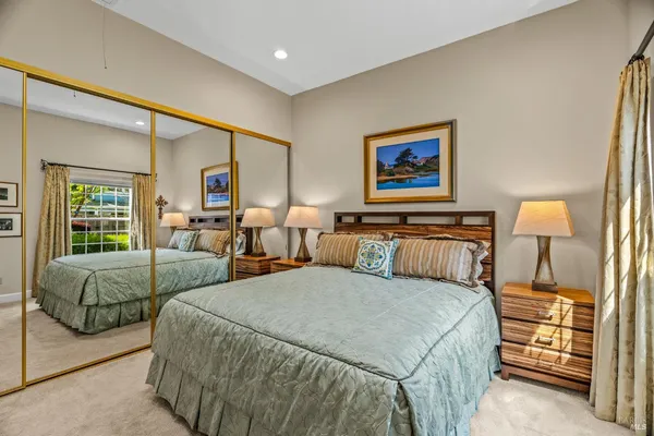 a bedroom with two beds and painting on the wall