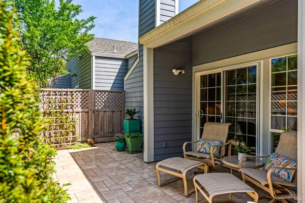 a view of a patio with table and chairs with wooden fence and plants