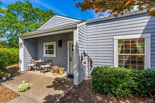 a view of a patio with chair and tables back yard of the house