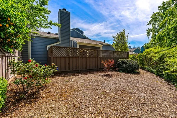 a front view of a house with a yard and covered with trees