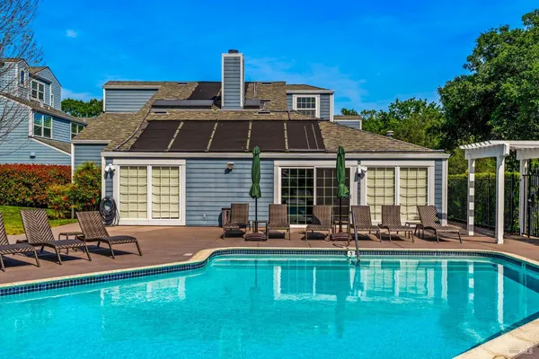 a front view of a house with swimming pool table and chairs