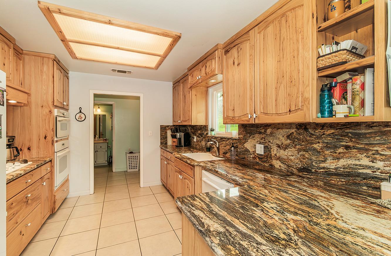 29979 Post Oak Road Tollhouse, CA 93667 - Photo 13 of 42 a large kitchen with a stove a sink dishwasher and a refrigerator with wooden floor