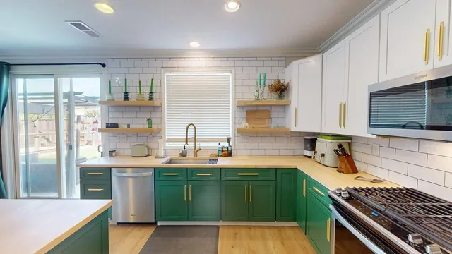 a kitchen with a sink a stove cabinets and a window