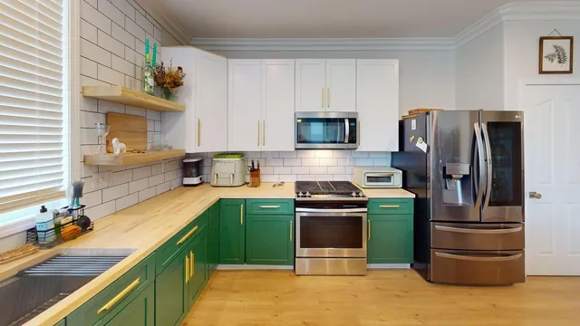 a kitchen with stainless steel appliances granite countertop a refrigerator stove and sink