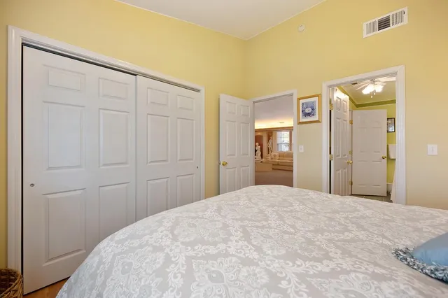 a bedroom with a bed dresser and wooden floor