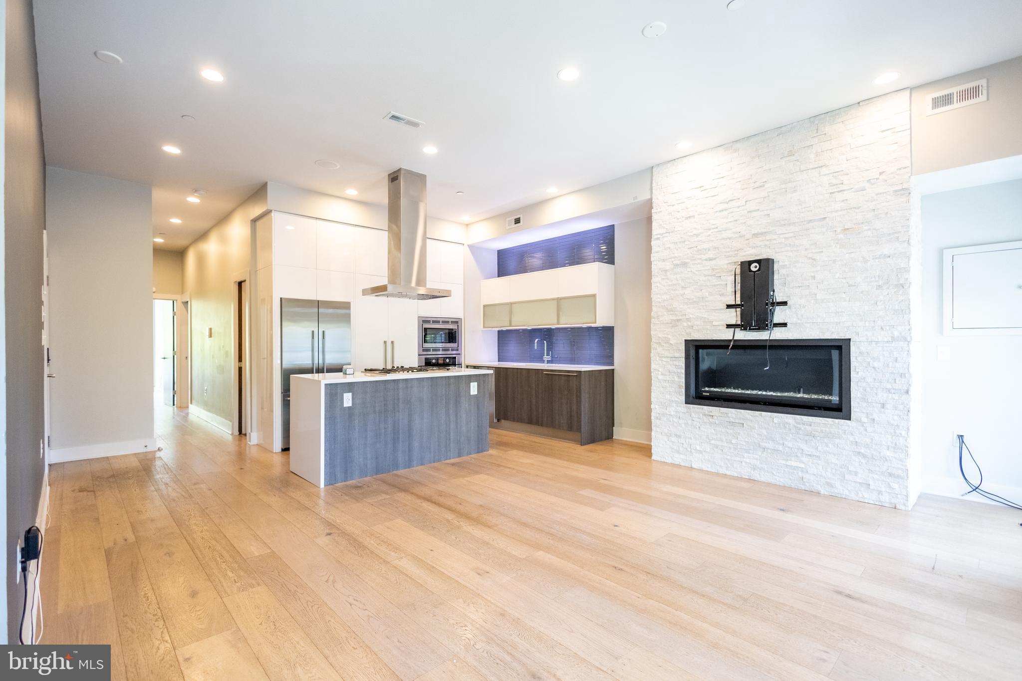 1476 Harvard Street Northwest, Unit C Washington, DC 20009 - Photo 10 of 20 a large kitchen with stainless steel appliances a large counter top a stove and a refrigerator