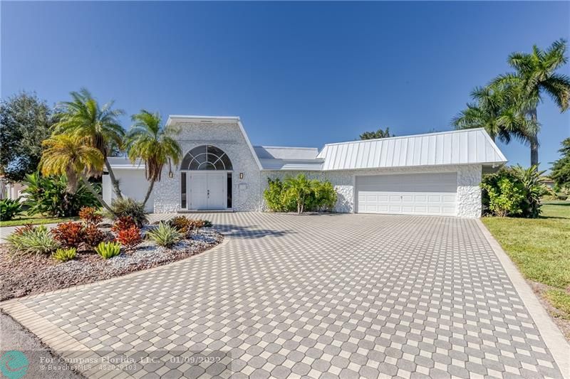 5709 Bamboo Circle Tamarac, FL 33319 - Photo 43 of 47 a front view of a house with a garden