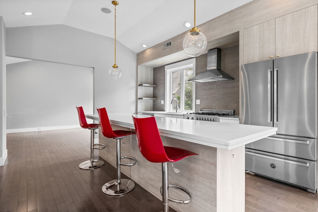 202 Rawson Road, Unit PH 3 Brookline, MA 02445 - Photo 4 of 17 a kitchen with stainless steel appliances kitchen island granite countertop a table chairs and a refrigerator