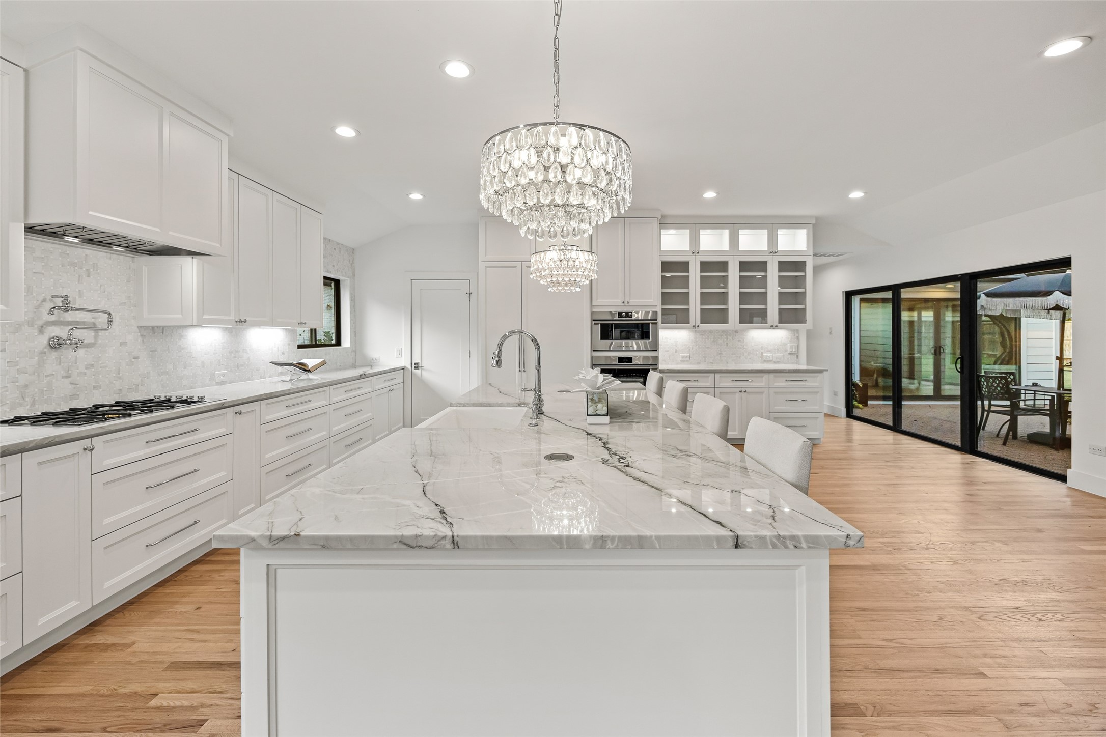 5658 Del Monte Drive Houston, TX 77056 - Photo 3 of 35 a large kitchen with granite countertop a sink and white cabinets with wooden floor