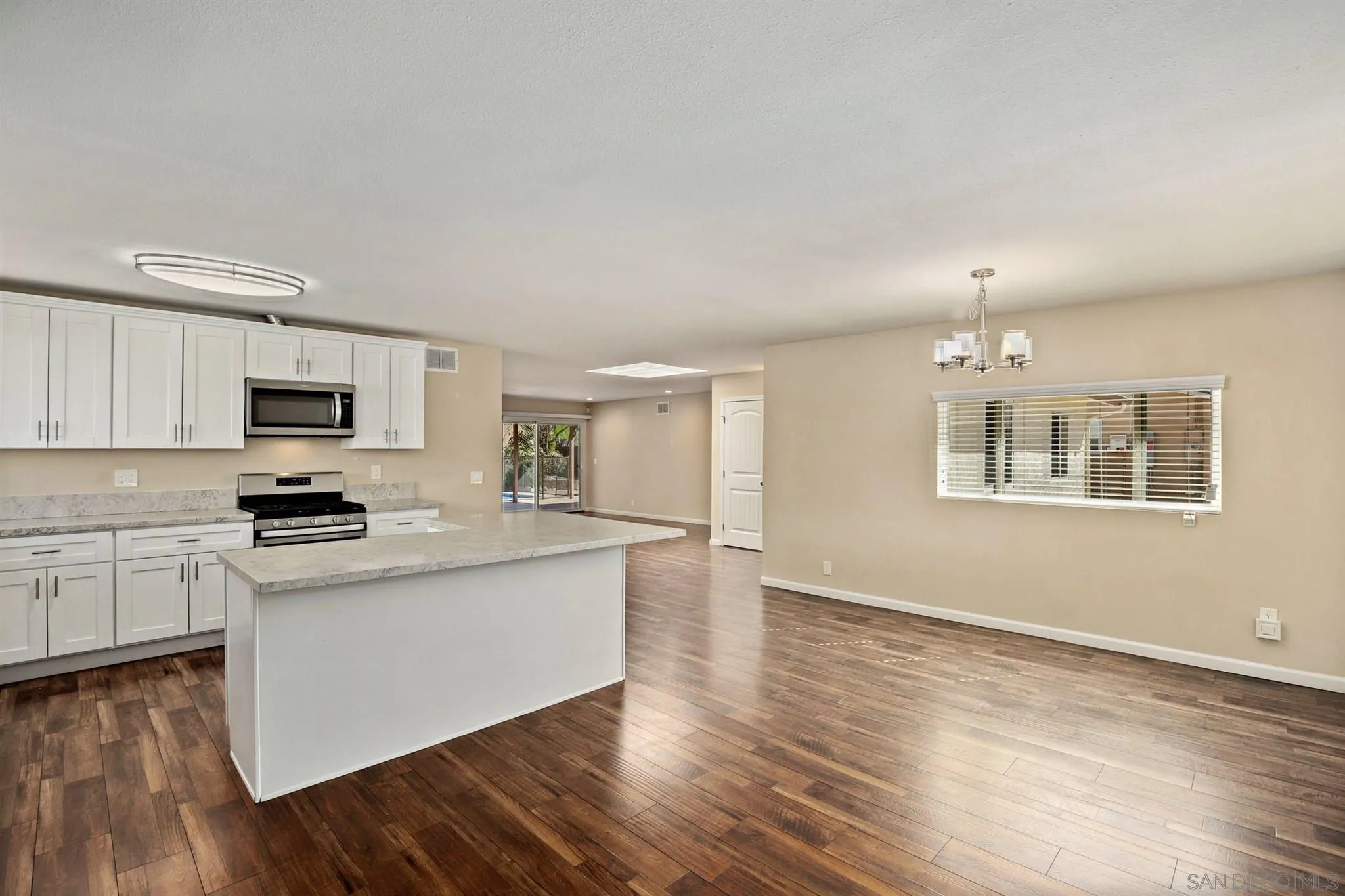 13441 Tobiasson Road Poway, CA 92064 - Photo 5 of 29 a kitchen with stainless steel appliances granite countertop a stove top oven a sink dishwasher and a refrigerator with wooden floor