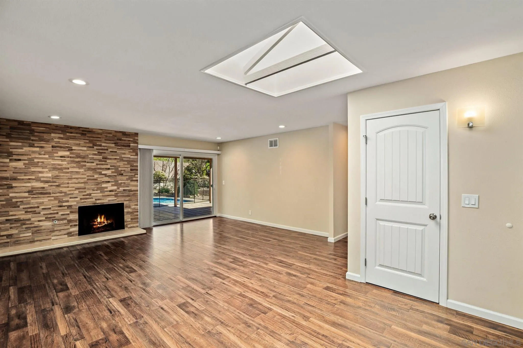 13441 Tobiasson Road Poway, CA 92064 - Photo 8 of 29 an empty room with wooden floor fireplace and windows