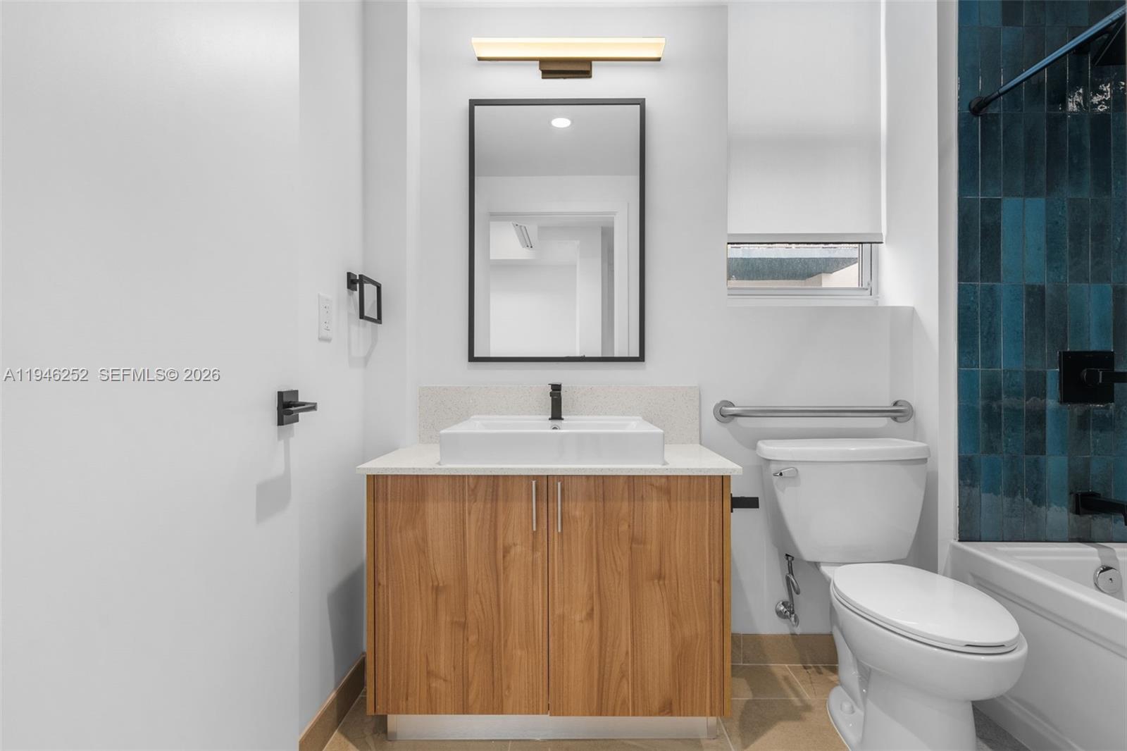 650 Southwest 1st Street, Unit 306 Miami, FL 33130 - Photo 8 of 16 a bathroom with a sink vanity mirror and toilet