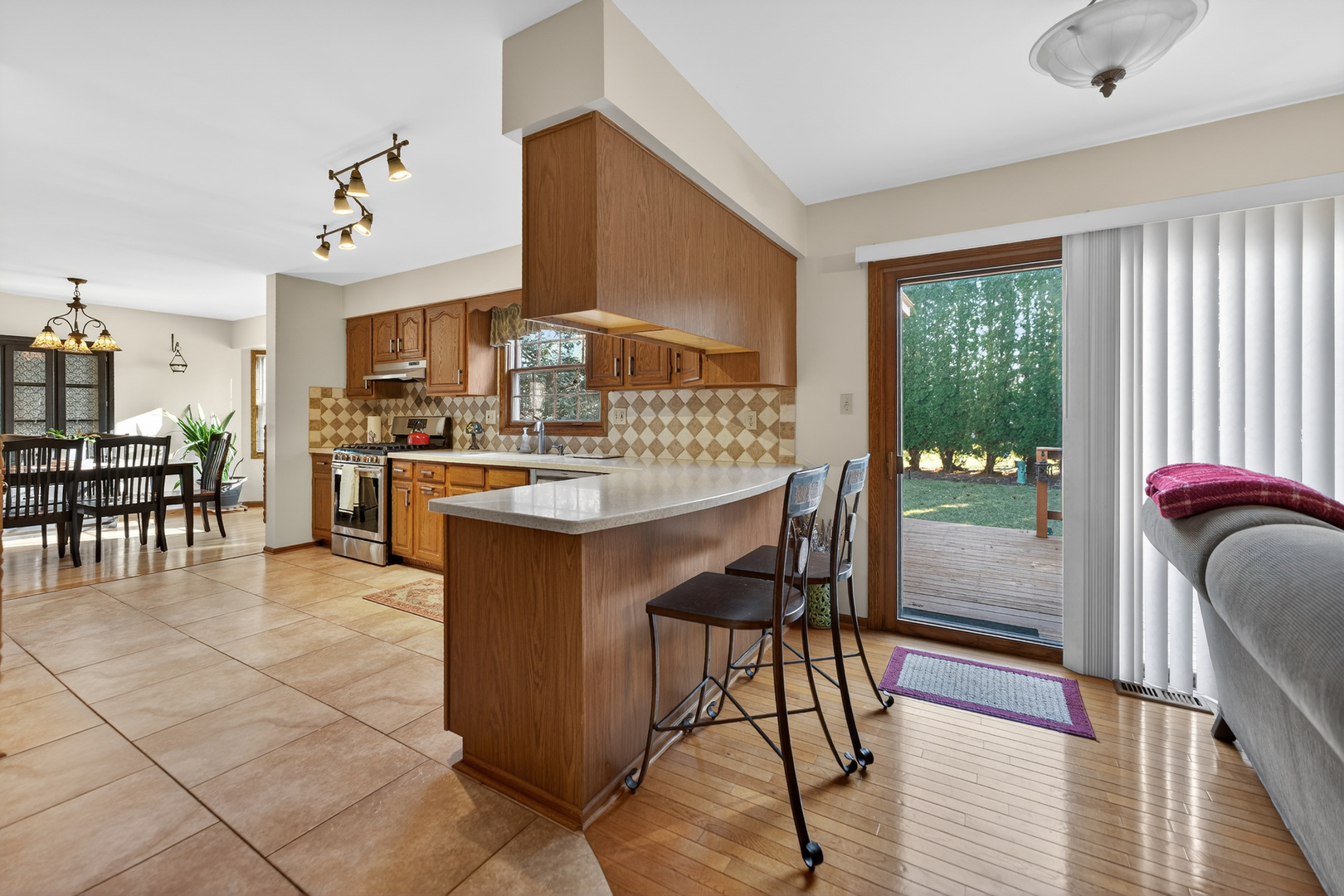 1524 John Street Sycamore, IL 60178 - Photo 14 of 52 a kitchen with stainless steel appliances kitchen island granite countertop a stove a refrigerator a sink a dining table and chairs with wooden floor