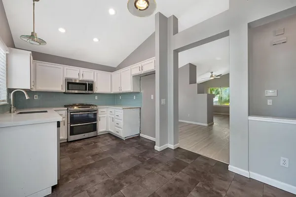 a kitchen with stainless steel appliances granite countertop a refrigerator and a stove top oven