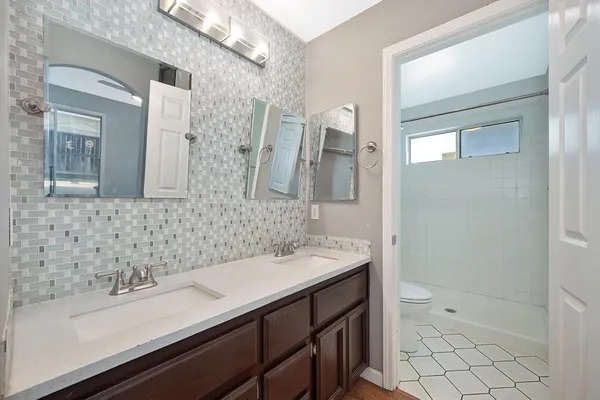 a bathroom with a sink a toilet and shower