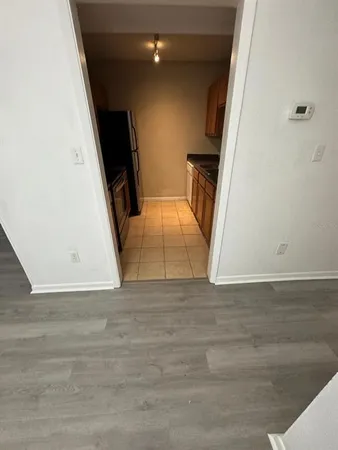an empty room with wooden floor and bathroom view