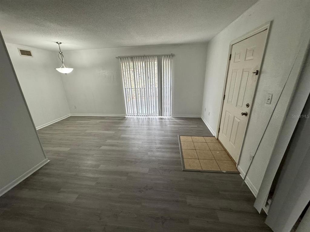 507 Northwest 39th Road, Unit 220 Gainesville, FL 32607 - Photo 14 of 21 an empty room with wooden floor and bathroom view