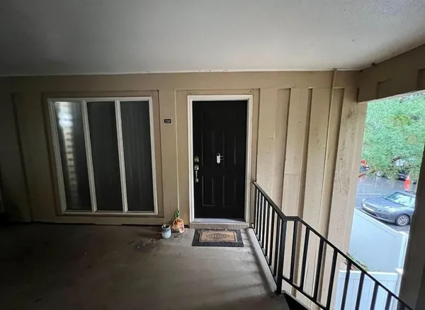a view of a hallway with wooden floor and stairs