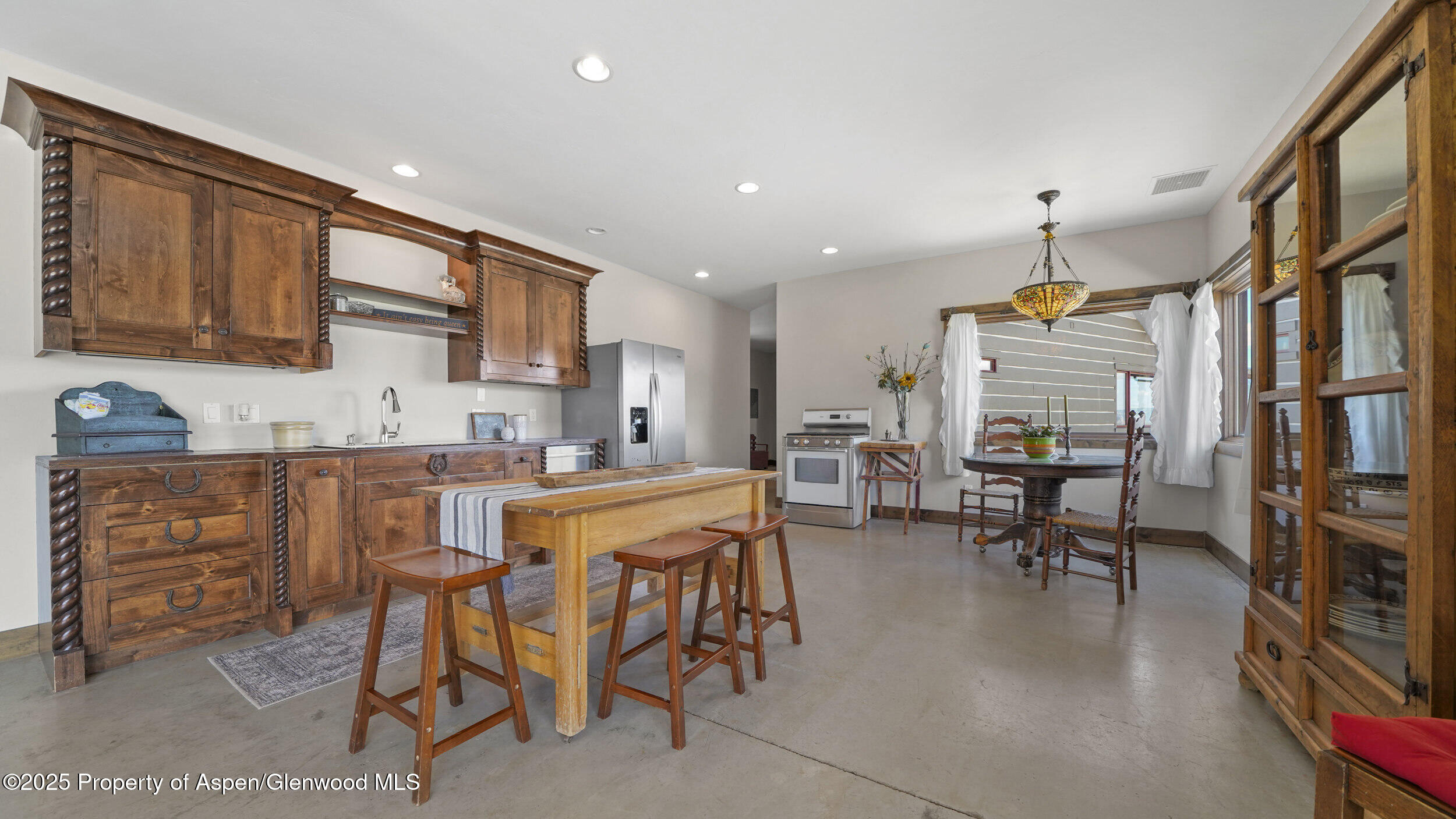 164 Booms Place Rifle, CO 81650 - Photo 13 of 33 a kitchen with stainless steel appliances kitchen island granite countertop a table and chairs in it