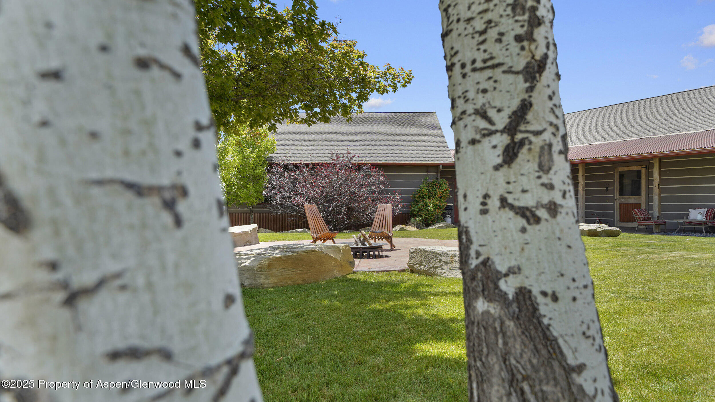 164 Booms Place Rifle, CO 81650 - Photo 20 of 33 a view of a backyard with table and chairs potted plants and large tree