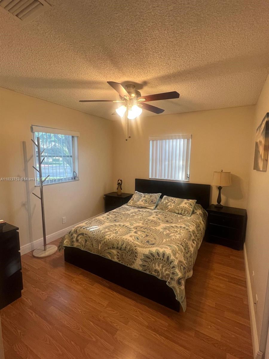 18906 Schooner Drive Boca Raton, FL 33496 - Photo 11 of 15 a bedroom with a bed and a chandelier