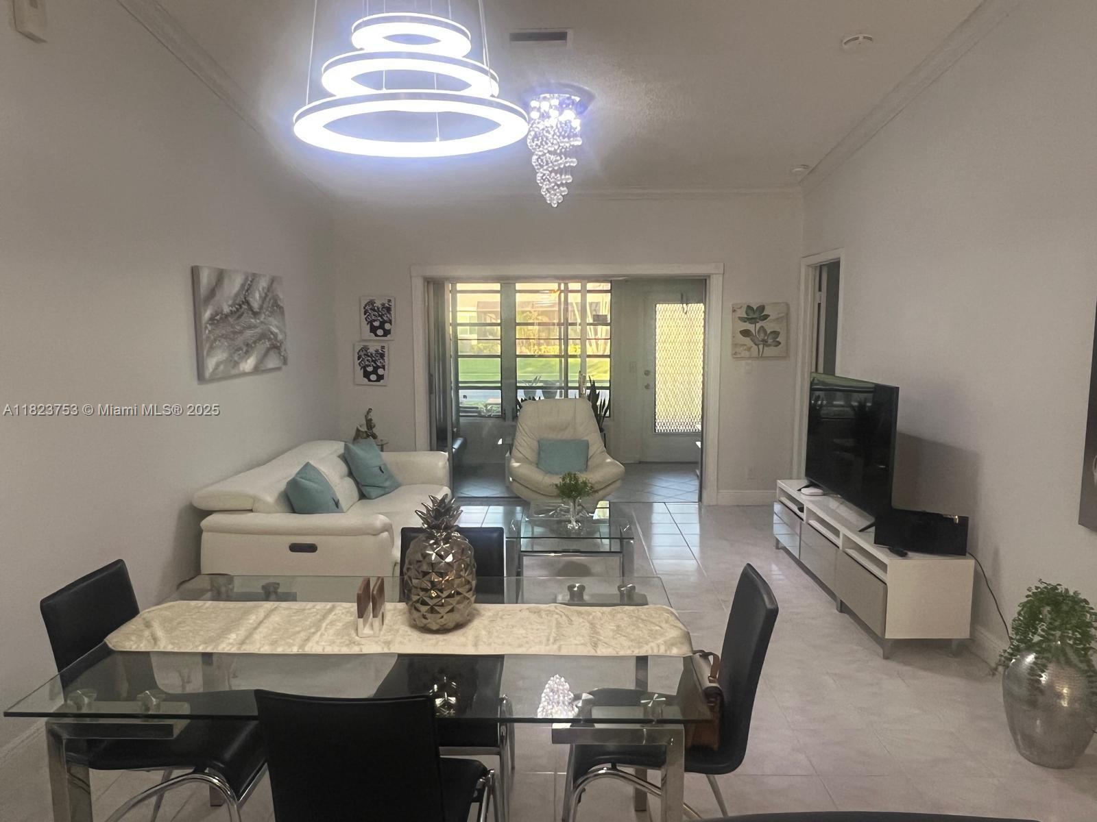 18906 Schooner Drive Boca Raton, FL 33496 - Photo 5 of 15 a view of a dining room with furniture a chandelier and wooden floor