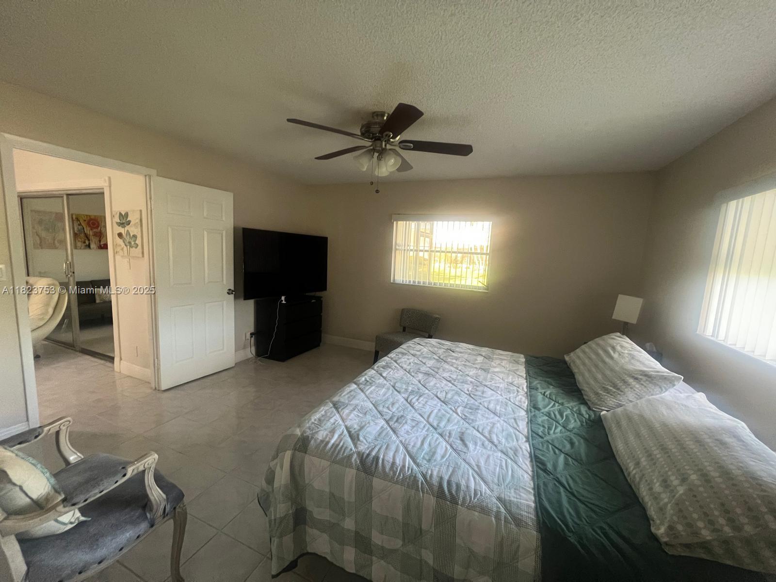 18906 Schooner Drive Boca Raton, FL 33496 - Photo 9 of 15 a bedroom with a bed and a chandelier