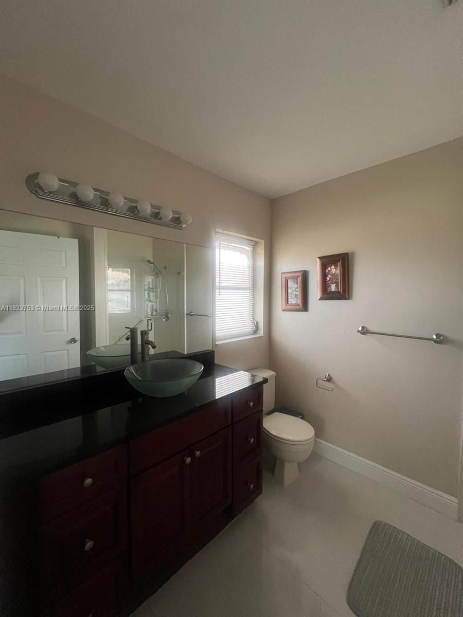 18906 Schooner Drive Boca Raton, FL 33496 - Photo 10 of 15 a bathroom with a granite countertop sink toilet and mirror