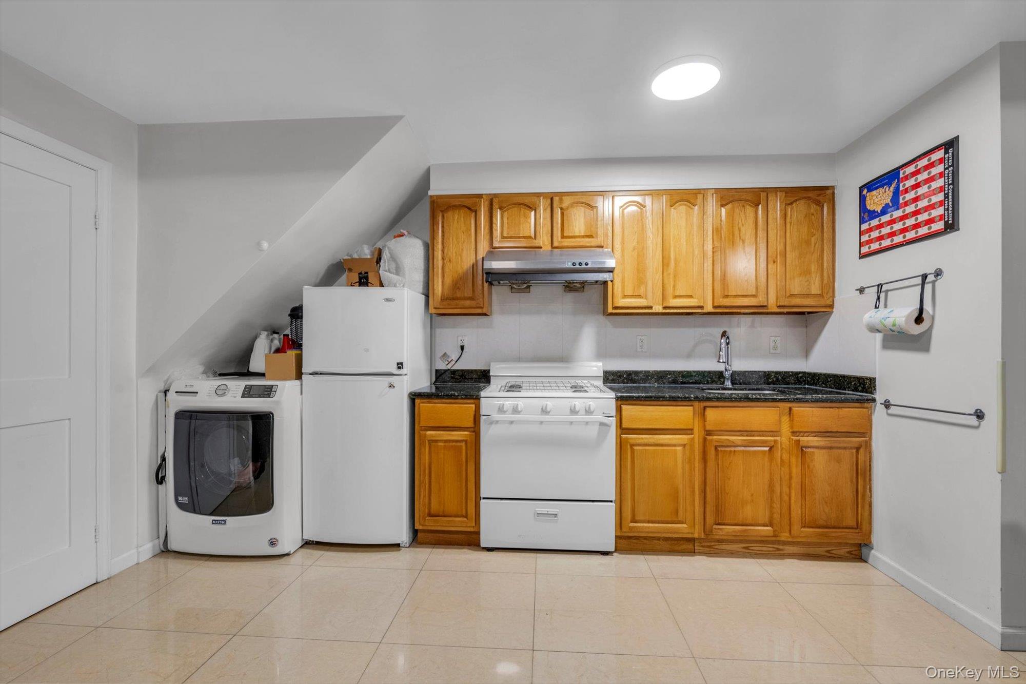 50-33 68th Street Queens, NY 11377 - Photo 13 of 17 a kitchen with stainless steel appliances granite countertop a stove a sink and a refrigerator