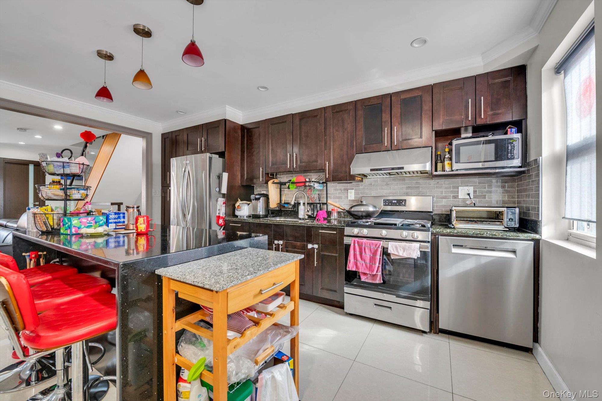 50-33 68th Street Queens, NY 11377 - Photo 6 of 17 a kitchen with stainless steel appliances granite countertop a refrigerator sink and cabinets