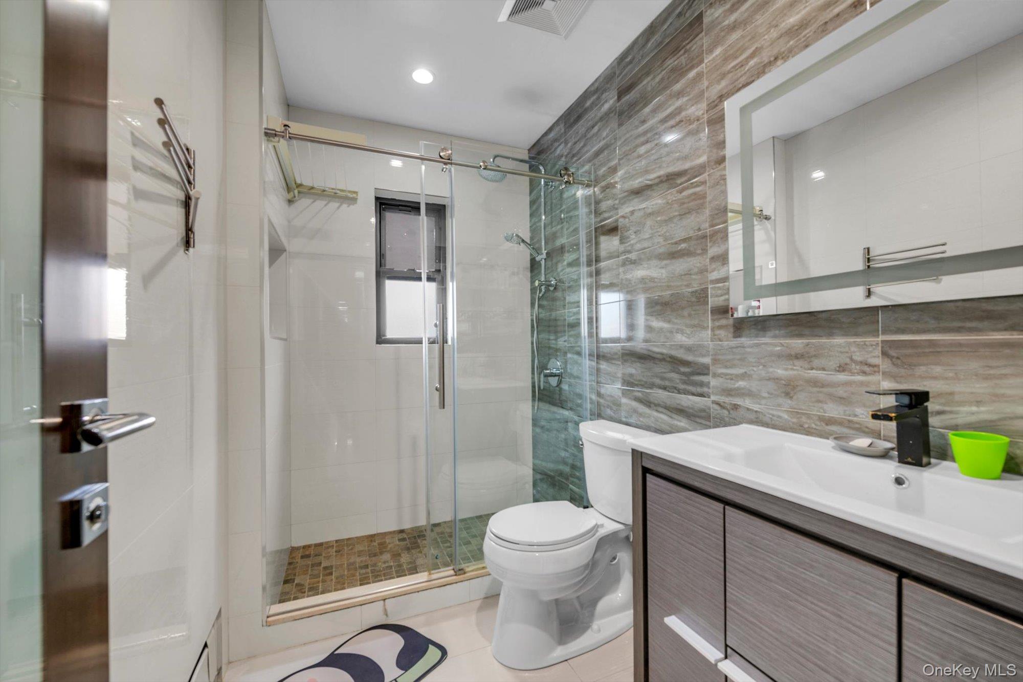 50-33 68th Street Queens, NY 11377 - Photo 10 of 17 a bathroom with a sink a toilet a mirror and shower