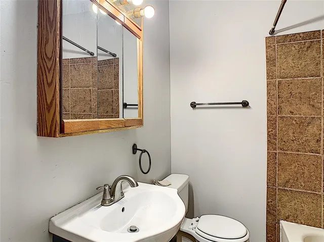 a bathroom with a sink mirror and toilet