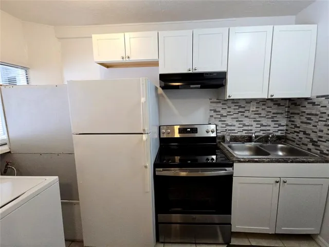 a kitchen with a sink and white cabinets