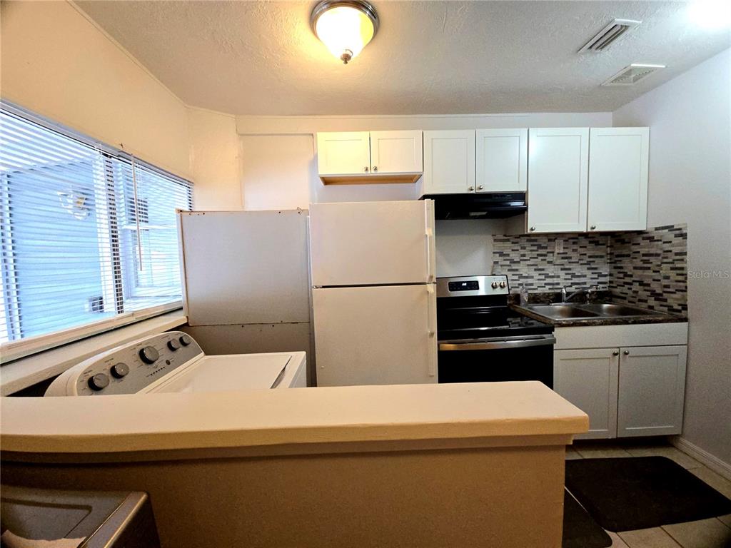 1839 Salem Road, Unit B Lakeland, FL 33803 - Photo 3 of 24 a kitchen with a refrigerator and a stove top oven